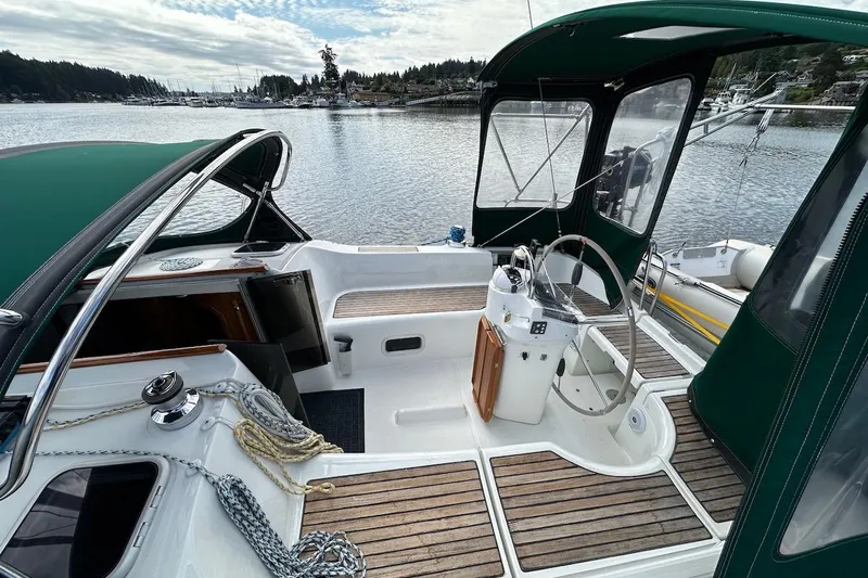 Tina C Yacht Photos Pics 2001 Beneteau 361 sailboat cockpit with green canopy, docked in a serene marina.