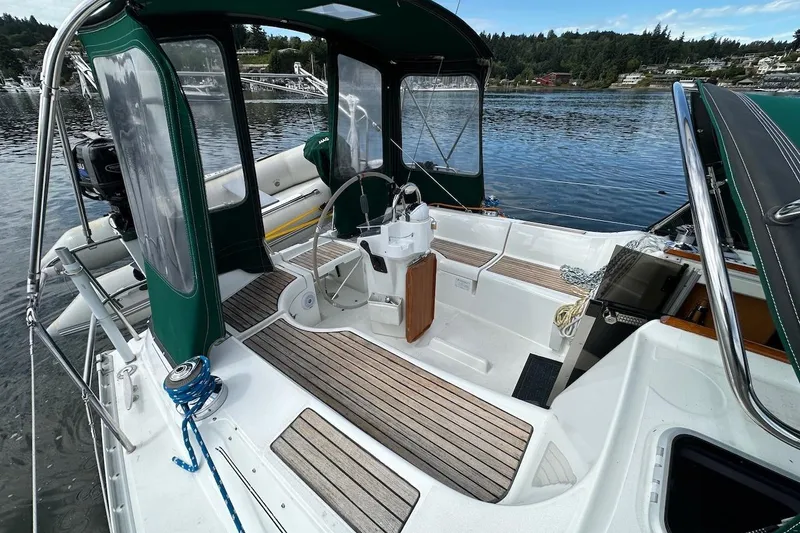 Tina C Yacht Photos Pics 2001 Beneteau 361 sailboat cockpit with green canopy, docked on a serene lake.