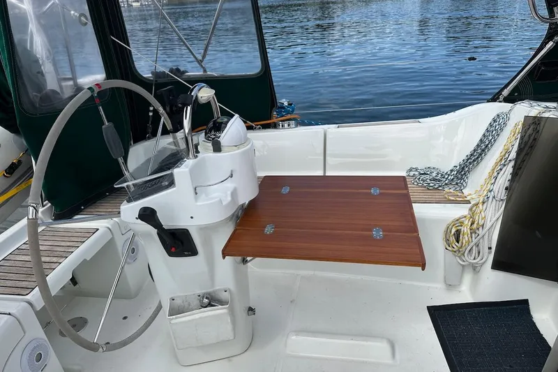 Tina C Yacht Photos Pics Cockpit of 2001 Beneteau 361 sailboat with steering wheel and wooden table.