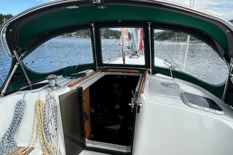 Tina C Yacht Photos Pics 2001 Beneteau 361 sailboat cockpit with green canopy, docked on a serene lake.