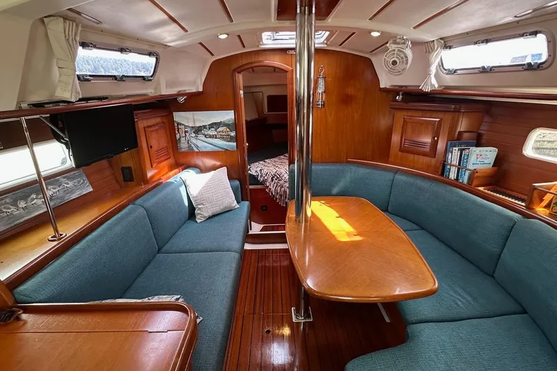 Tina C Yacht Photos Pics Interior of 2001 Beneteau 361 sailboat with cozy seating and wooden finishes.