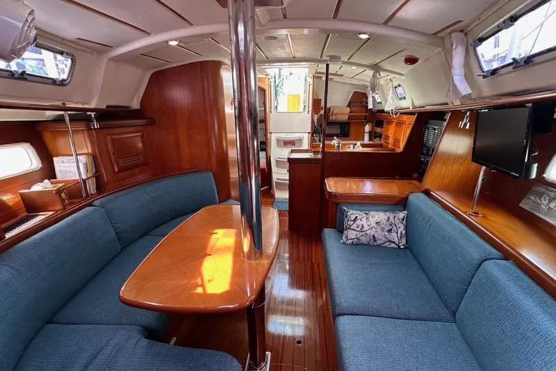 Tina C Yacht Photos Pics Interior of 2001 Beneteau 361 sailboat with wood finish and blue seating.