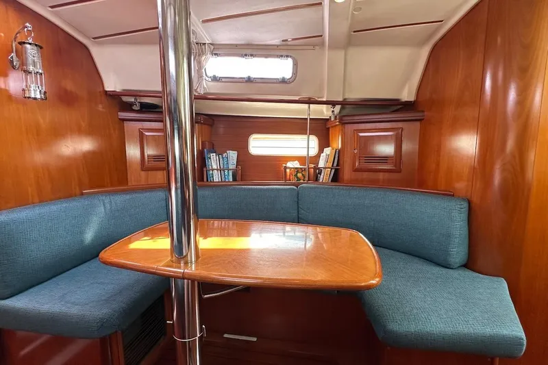 Tina C Yacht Photos Pics Interior of 2001 Beneteau 361 sailboat with wooden finish and blue seating.