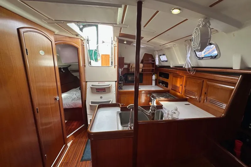 Tina C Yacht Photos Pics Interior of 2001 Beneteau 361 sailboat with wood cabinetry and compact kitchen.