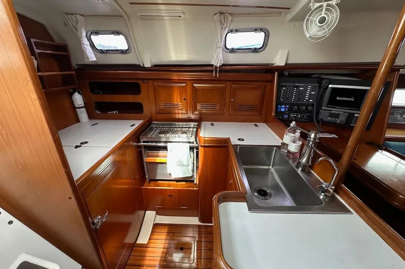 Tina C Yacht Photos Pics Interior of 2001 Beneteau 361 yacht kitchen with wood cabinetry and modern appliances.