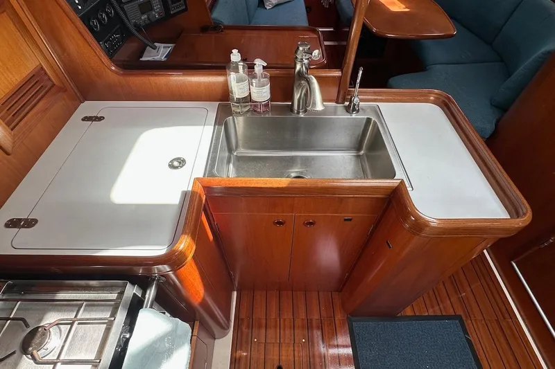 Tina C Yacht Photos Pics Galley kitchen in 2001 Beneteau 361 sailboat with sink and wooden cabinetry.