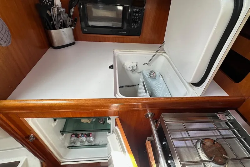 Tina C Yacht Photos Pics Galley kitchen in 2001 Beneteau 361 sailboat with stove, fridge, and microwave.