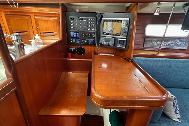 Tina C Yacht Photos Pics Navigation station inside 2001 Beneteau 361 sailboat, featuring control panel and seating.