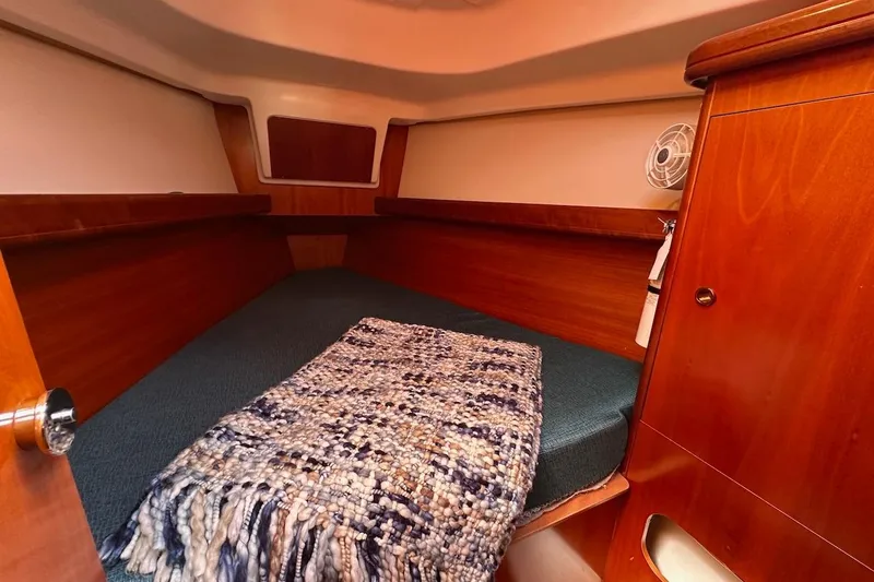 Tina C Yacht Photos Pics Cozy cabin interior of 2001 Beneteau 361 sailboat with wooden finish and bed.