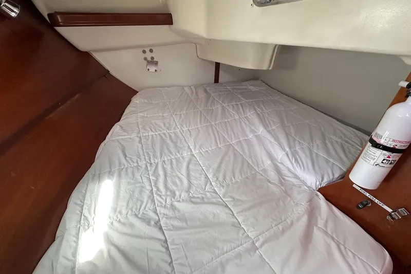Tina C Yacht Photos Pics Cozy cabin interior of 2001 Beneteau 361 sailboat with white bedding and fire extinguisher.