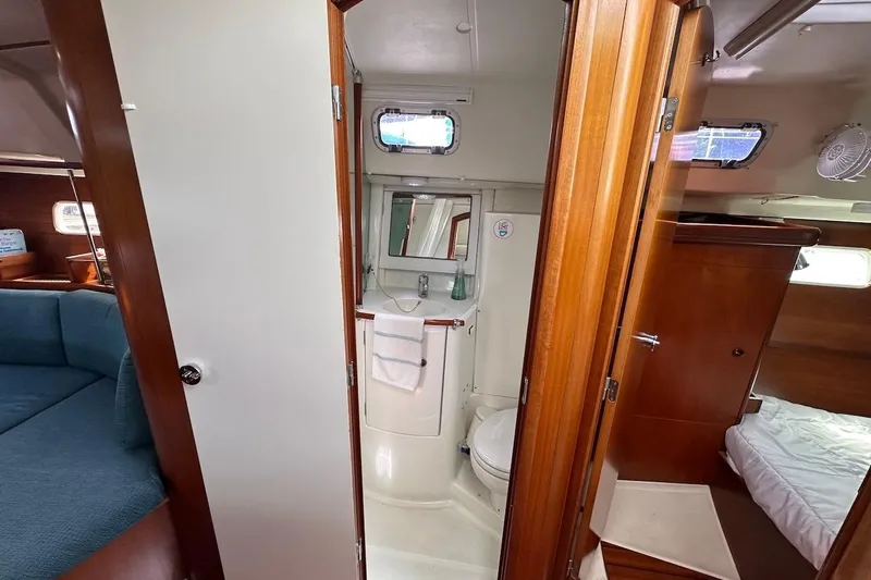 Tina C Yacht Photos Pics Interior of 2001 Beneteau 361 yacht showing bathroom, wooden cabinetry, and seating area.
