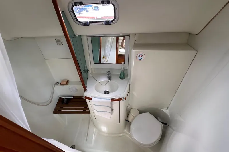 Tina C Yacht Photos Pics Compact bathroom in a 2001 Beneteau 361 sailboat with sink, toilet, and shower.