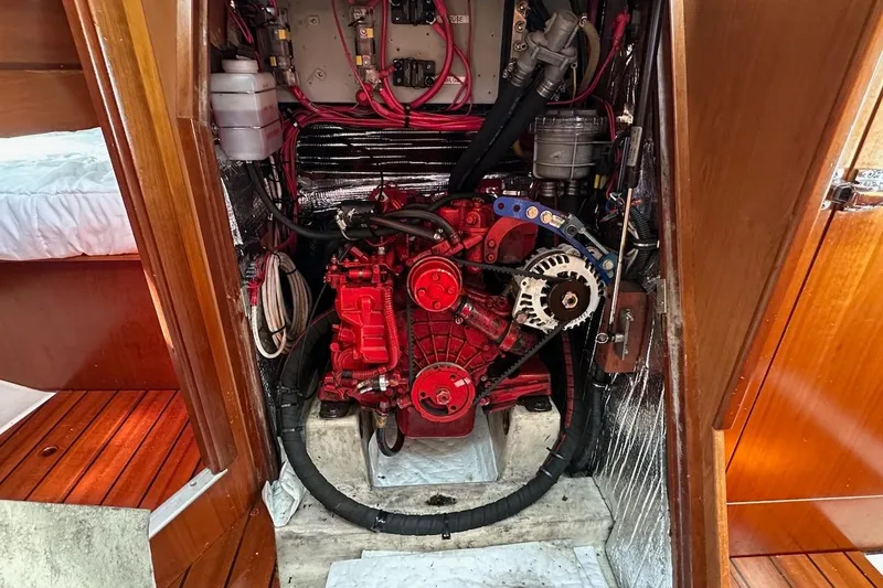 Tina C Yacht Photos Pics Engine compartment of a 2001 Beneteau 361 sailboat, featuring a red engine and wiring.