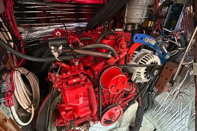 Tina C Yacht Photos Pics Engine compartment of a 2001 Beneteau 361 sailboat, featuring a red engine and wiring.