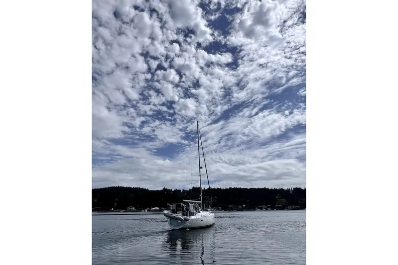 Tina C Yacht Photos Pics Sailboat Beneteau 361 (2001) on calm water under a cloudy sky.
