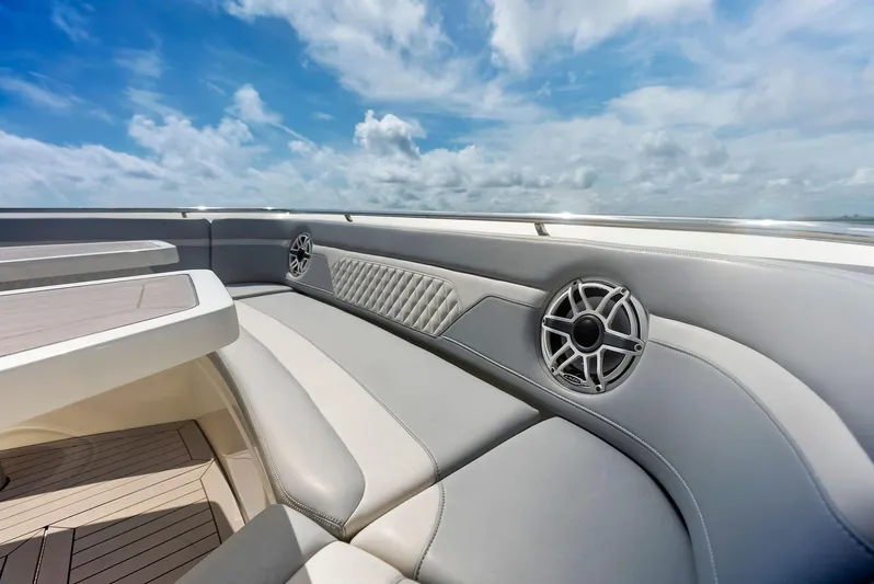 Bottom Line Yacht Photos Pics 2022 Scout LXF boat interior with luxurious seating and speakers under a blue sky.
