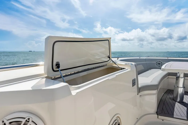 Bottom Line Yacht Photos Pics 2022 Scout LXF boat with open storage compartment, ocean view, and seating area.
