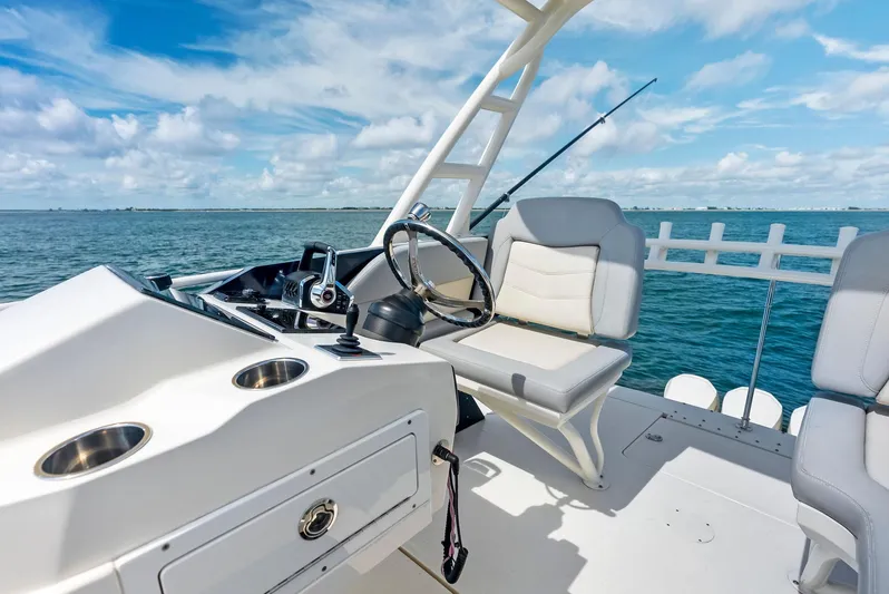 Bottom Line Yacht Photos Pics 2022 Scout LXF boat helm with ocean view, featuring modern seating and steering wheel.