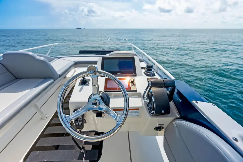 Bottom Line Yacht Photos Pics 2022 Scout LXF boat helm with ocean view, featuring modern controls and steering wheel.