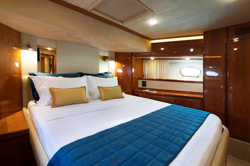  Yacht Photos Pics Luxurious bedroom interior of 2003 Ferretti Yachts 760 with elegant wood finishes and cozy bedding.