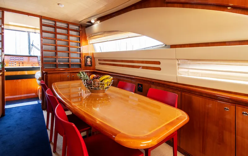  Yacht Photos Pics Luxurious dining area on 2003 Ferretti Yachts 760 with elegant wood finish and red chairs.
