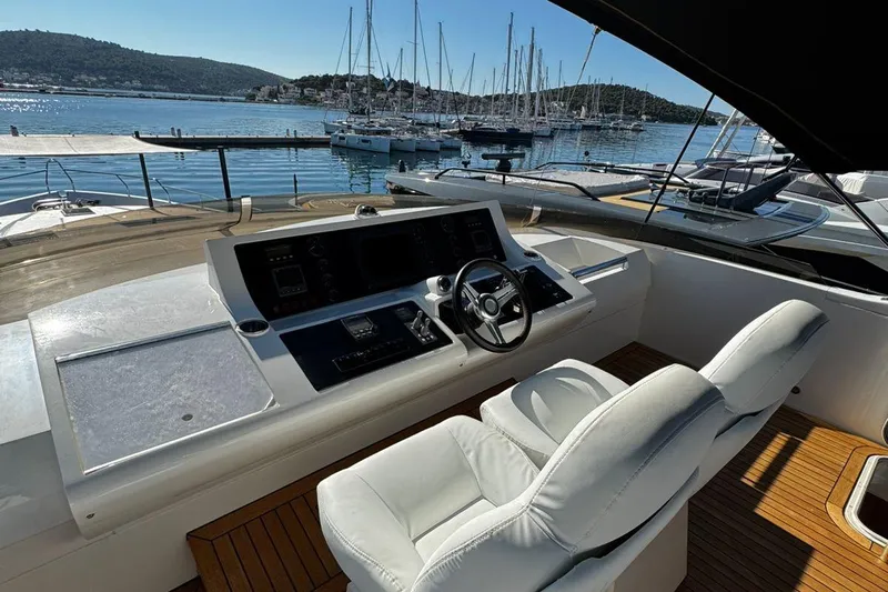  Yacht Photos Pics Luxurious 2008 Princess V85 yacht helm with white seating, overlooking marina and sailboats.