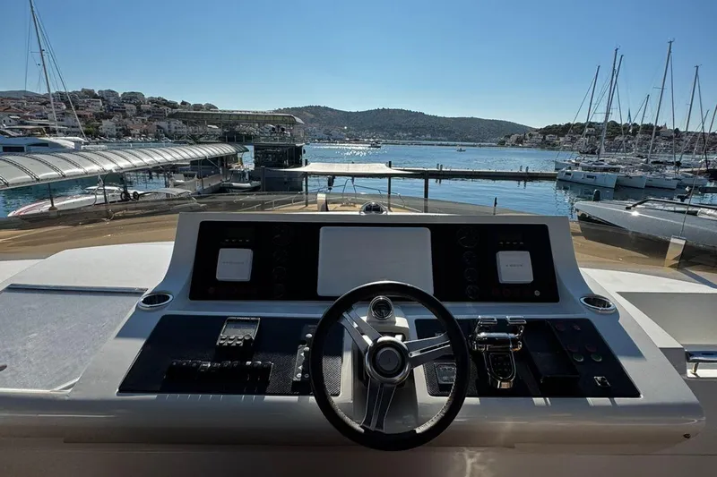  Yacht Photos Pics Helm of 2008 Princess V85 yacht overlooking marina with sailboats and scenic hills.