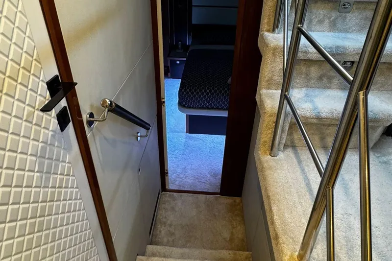  Yacht Photos Pics Staircase and hallway inside 2008 Princess V85 yacht, featuring carpeted steps and metal railings.
