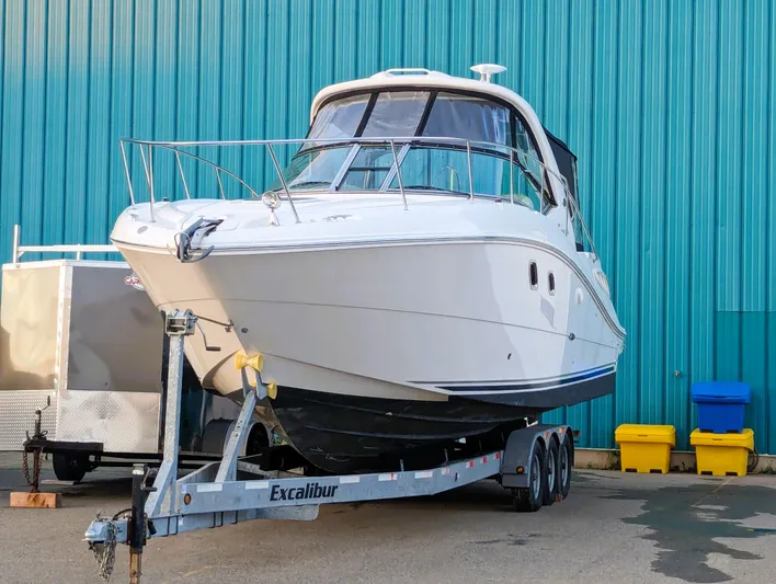  Yacht Photos Pics 2008 Sea Ray 330 Sundancer boat on trailer, parked by blue building.