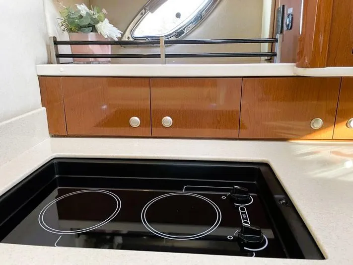  Yacht Photos Pics 2008 Sea Ray 330 Sundancer kitchen with electric stove and wooden cabinetry.