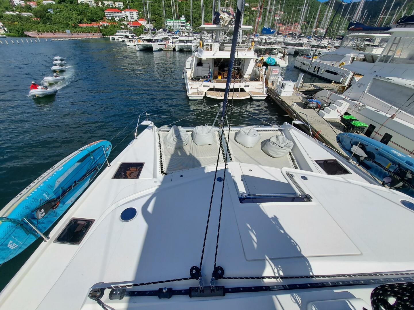 Leopard 58 yacht docked at marina, surrounded by boats and scenic waterfront.
