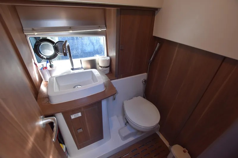 Indian Summer Yacht Photos Pics 2016 Sealine C330 yacht bathroom with sink, toilet, and wooden cabinetry.