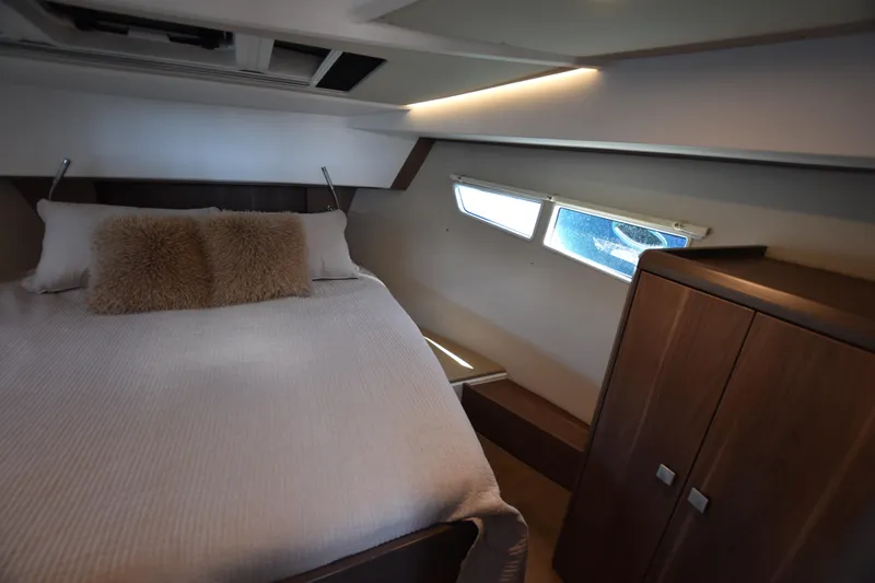 Indian Summer Yacht Photos Pics Cozy bedroom interior of 2016 Sealine C330 yacht with plush bedding and wooden cabinetry.