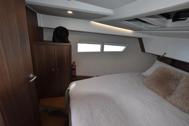 Indian Summer Yacht Photos Pics 2016 Sealine C330 cabin interior with bed, wooden cabinetry, and window.