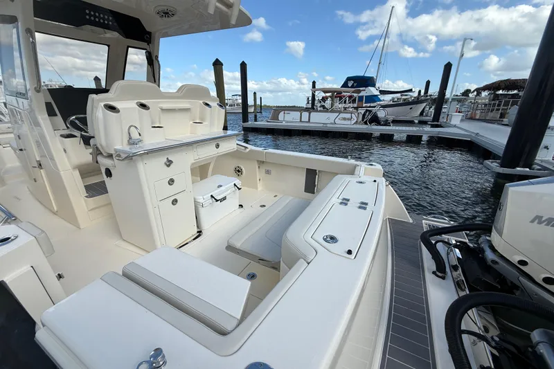  Yacht Photos Pics 2026 Scout 288 LXF boat interior at marina, showcasing seating and storage features.