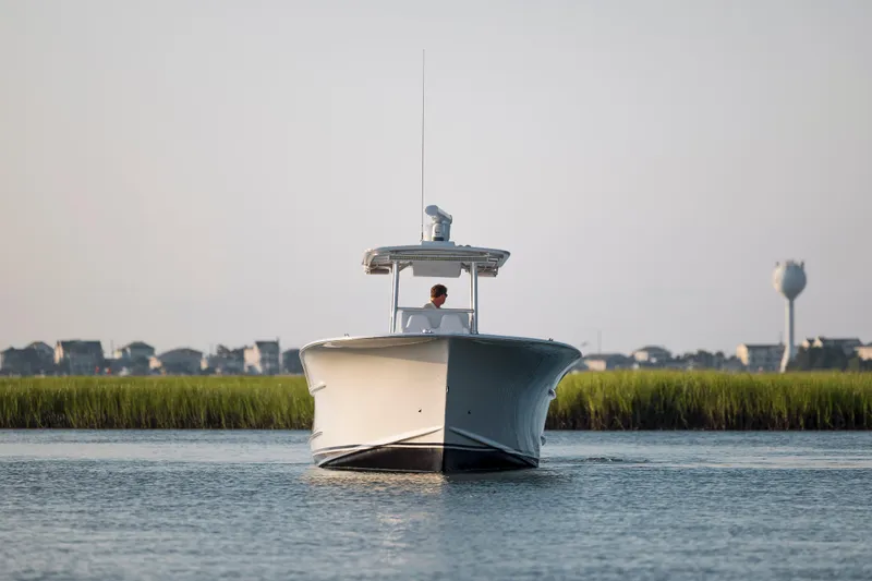  Yacht Photos Pics 2019 Willis 33 Center Console boat on calm water with grassy shoreline.