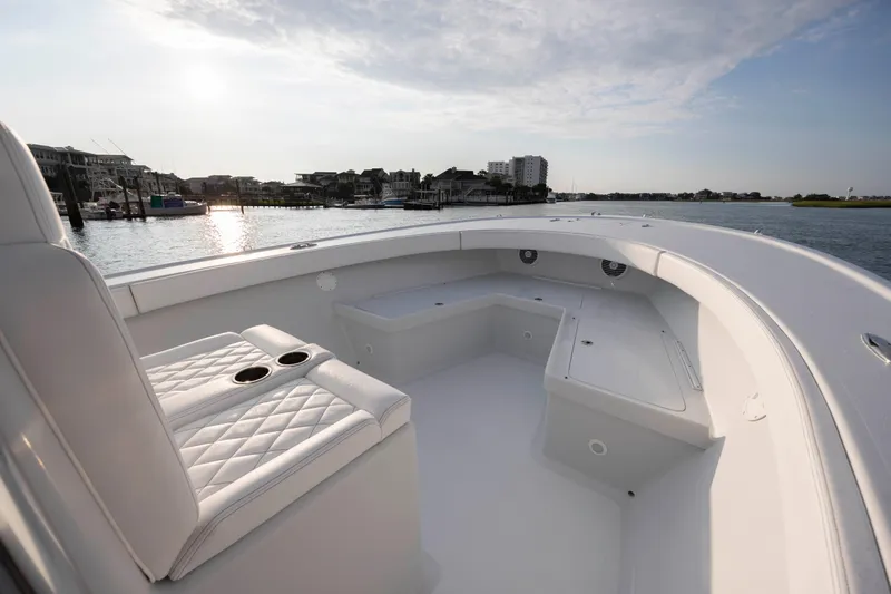  Yacht Photos Pics 2019 Willis 33 Center Console boat interior with white seating, docked near waterfront buildings.