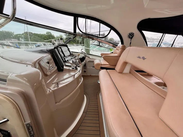 At Last Yacht Photos Pics 2004 Sea Ray 420 Sundancer cockpit with beige seating and modern navigation equipment.