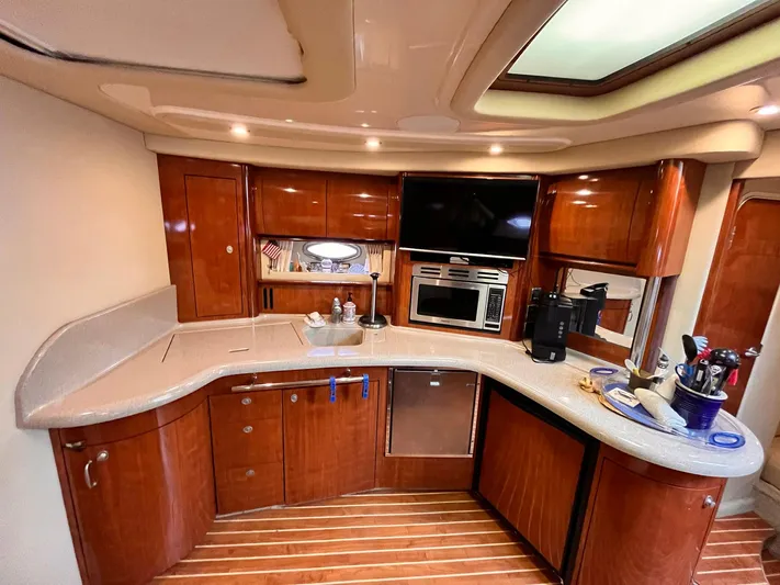 At Last Yacht Photos Pics Luxurious 2004 Sea Ray 420 Sundancer yacht kitchen with modern amenities and wood cabinetry.
