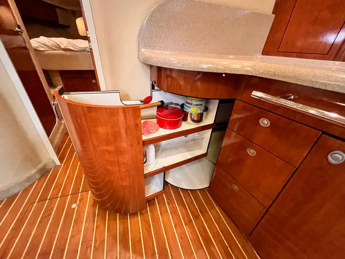 At Last Yacht Photos Pics 2004 Sea Ray 420 Sundancer kitchen with open wooden cabinets and modern countertop.