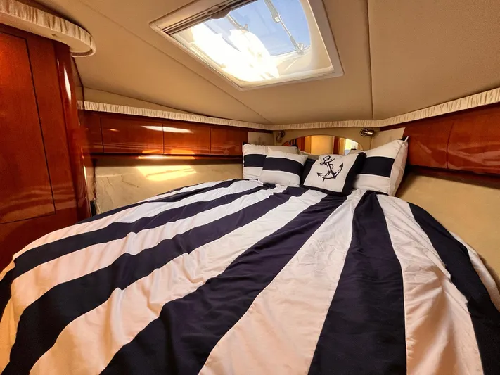 At Last Yacht Photos Pics Luxurious cabin interior of 2004 Sea Ray 420 Sundancer with striped bedding.