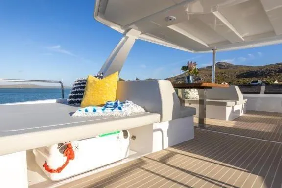  Yacht Photos Pics 2023 Leopard 46 Powercat yacht deck with seating, table, and scenic ocean view.