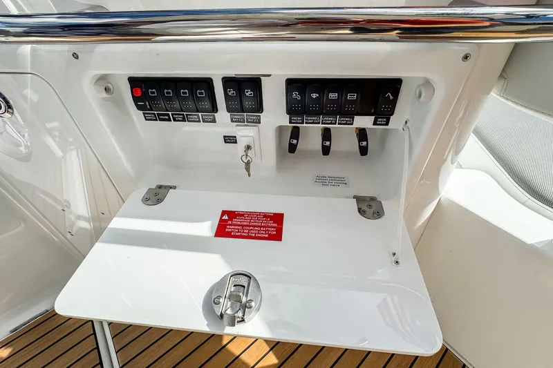  Yacht Photos Pics Control panel of 2026 Wellcraft 38 T-Top boat with switches and warning label.