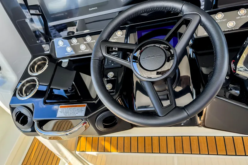  Yacht Photos Pics Steering wheel and controls of 2026 Wellcraft 38 T-Top boat, featuring modern dashboard design.
