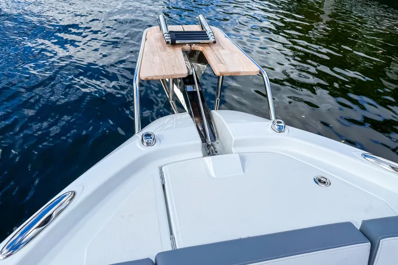  Yacht Photos Pics Bow view of 2026 Wellcraft 38 T-Top boat with wooden platform and water backdrop.