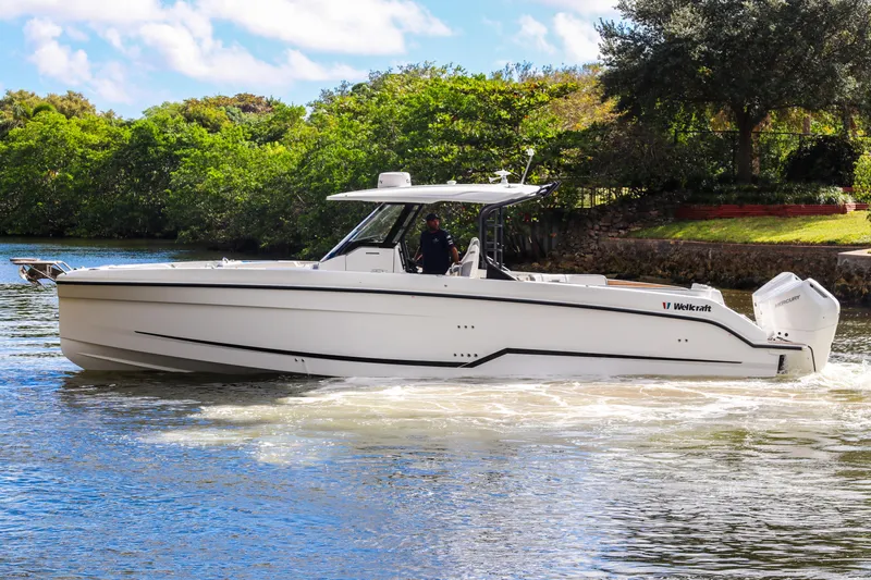  Yacht Photos Pics 2026 Wellcraft 38 T-Top boat cruising on a scenic waterway.