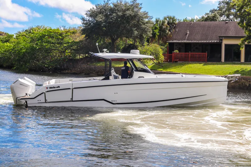  Yacht Photos Pics 2026 Wellcraft 38 T-Top boat cruising on a scenic waterway.