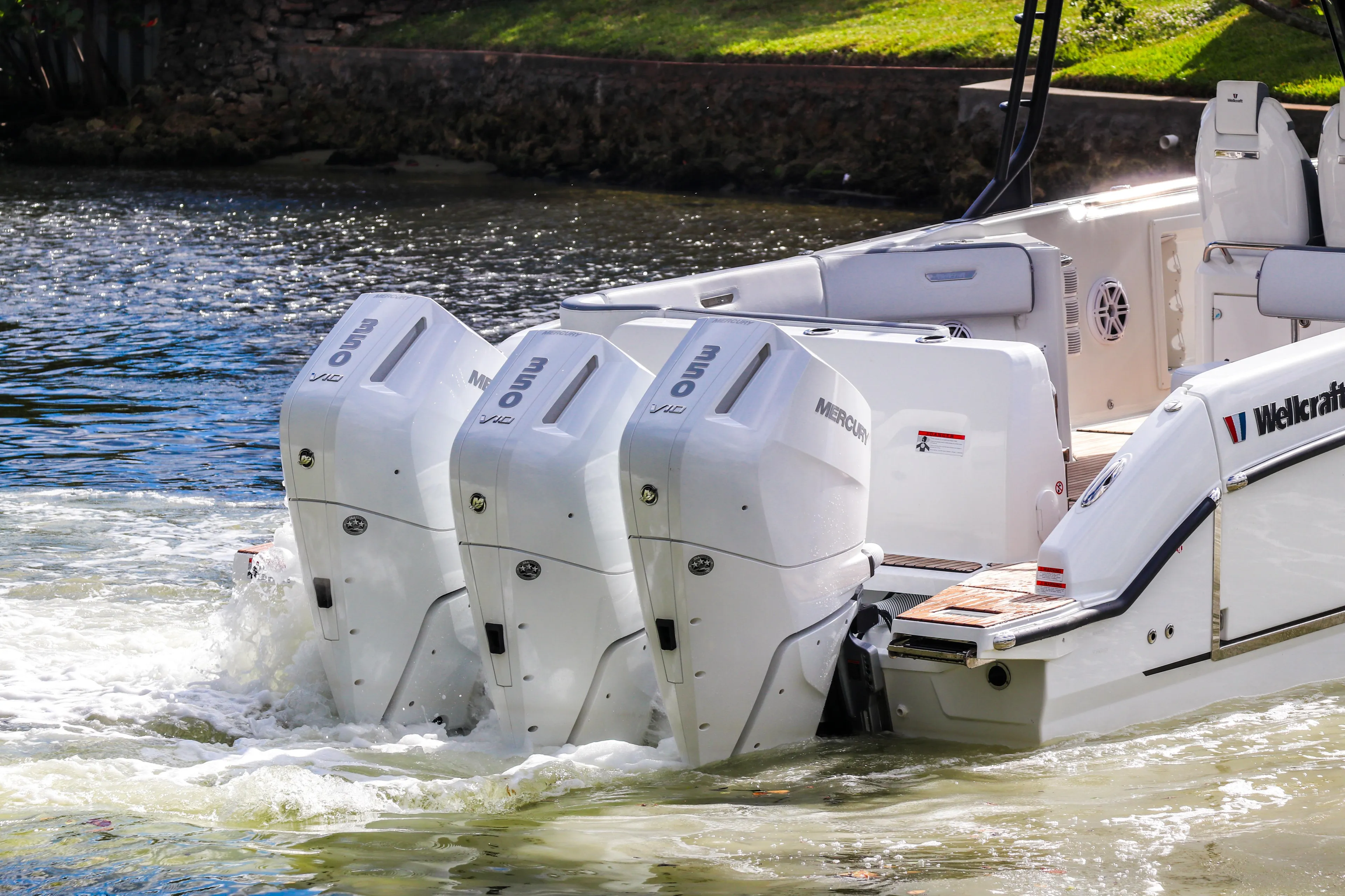 2026 Wellcraft 38 T-Top boat with triple Mercury outboard engines on water.