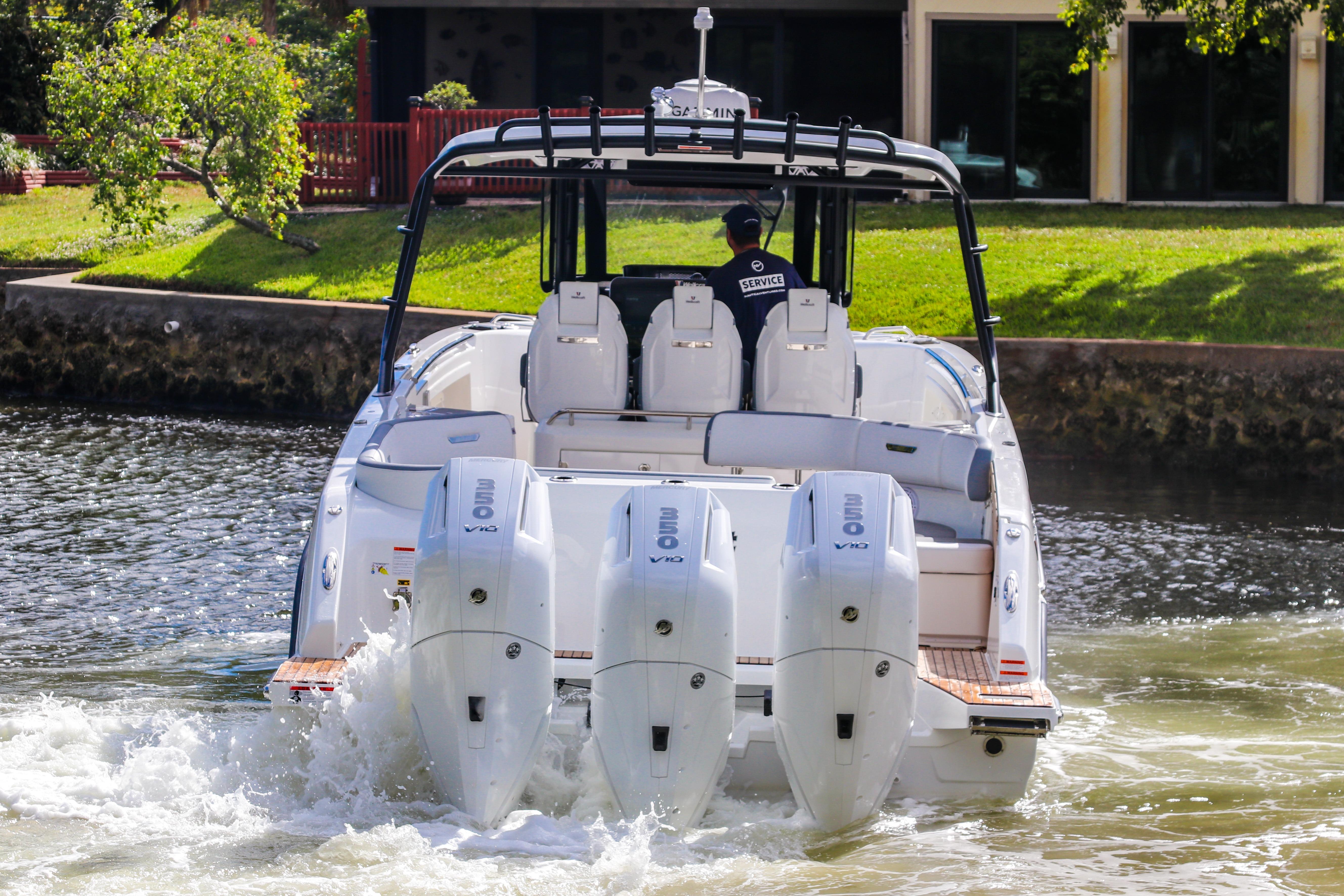 2026 Wellcraft 38 T-Top boat with quad engines cruising on a scenic waterway.