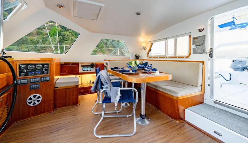 Nogal Yacht Photos Pics Luxurious interior of 2009 Chris White Atlantic 57 catamaran with dining area and navigation controls.